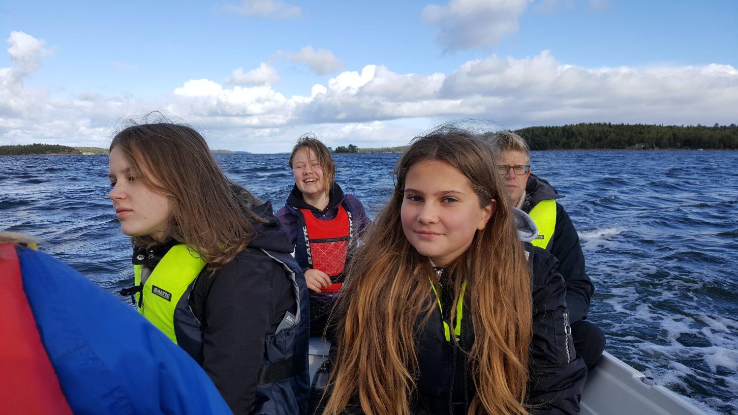 På vägen hem från Apagrundet styr Olga Åberg med biolgoiläraren Peter Rönnberg bredvid sig. Närmast kameran sitter Elin Kari från Kyrkbackens skola i Nagu. Foto: Carina Holm