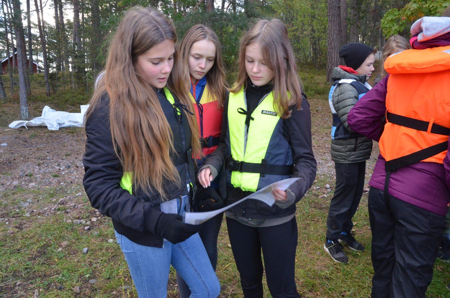 Nagueleverna Elin Kari, Linnea Nordqvist och Frida Hausen tar en titt på sjökortet innan de sätter sig i båten och styr mot Apagrundet. Foto: Carina Holm
