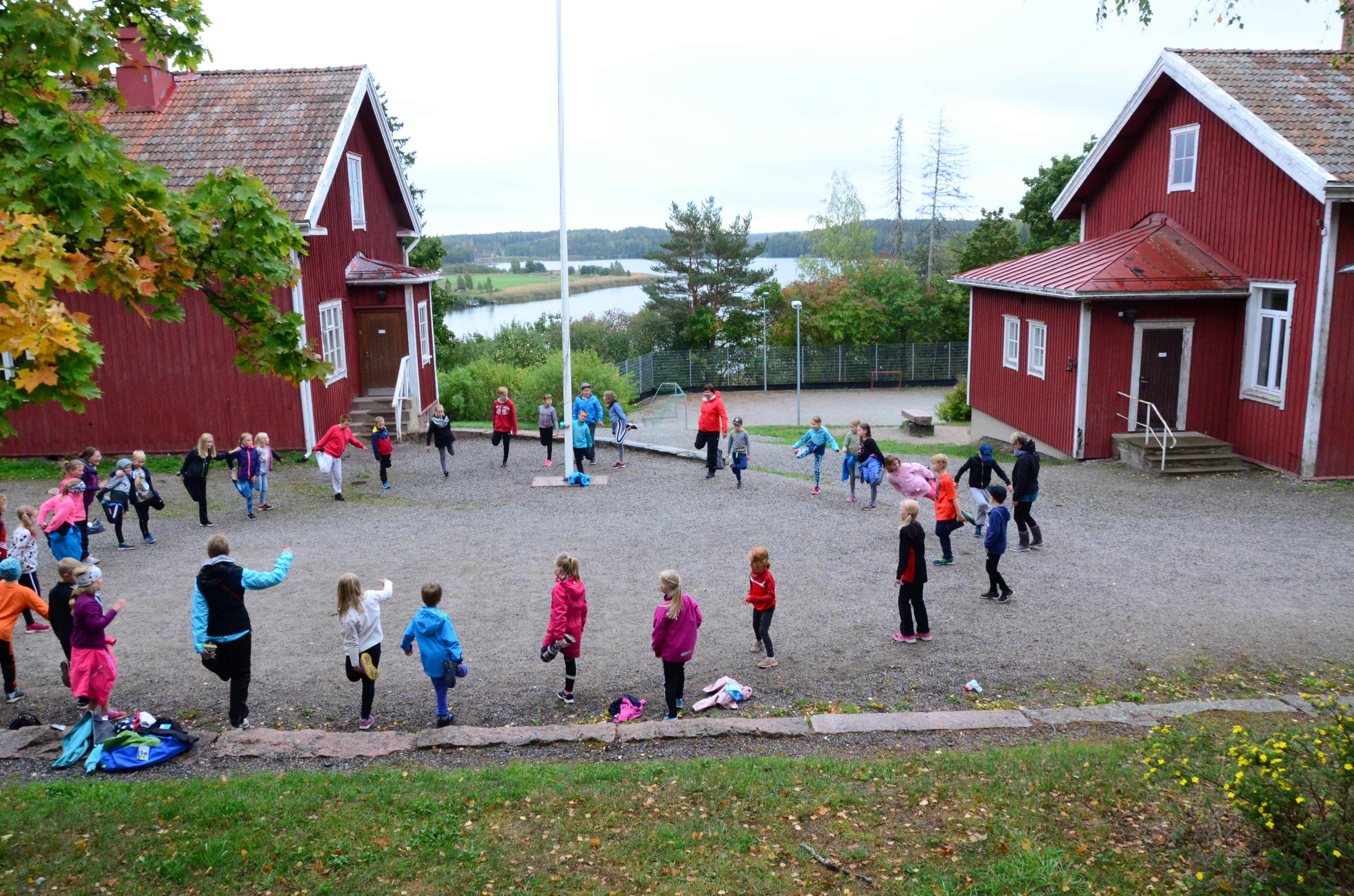 röda trähus och gård där barn leker