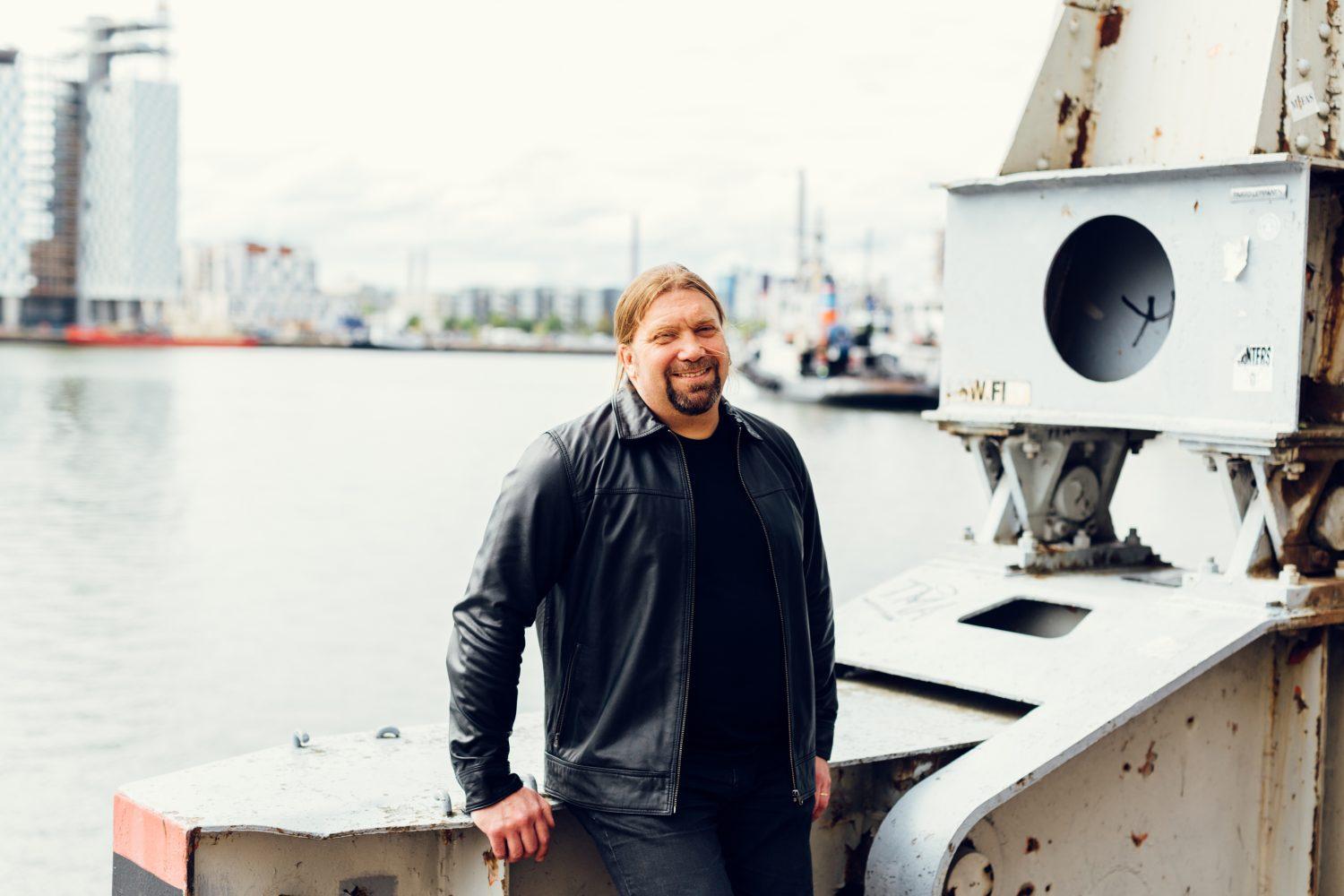 Leende man med hamn i bakgrunden.