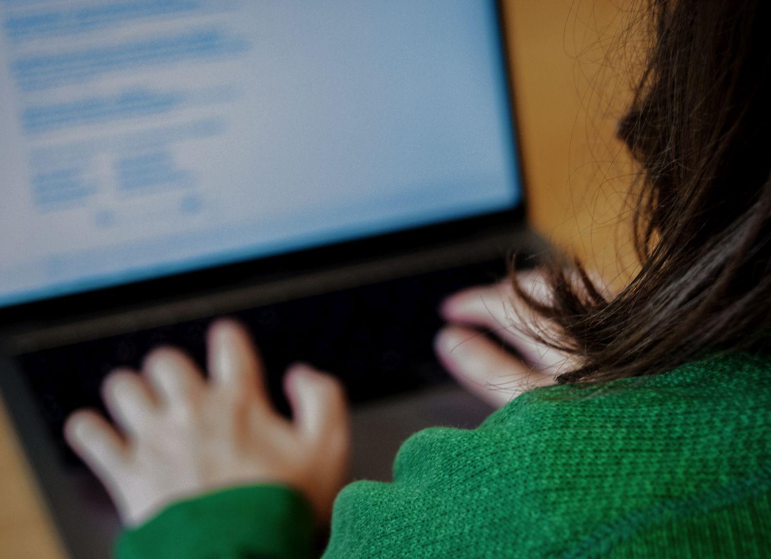 Kvinna sitter vid datorskärm