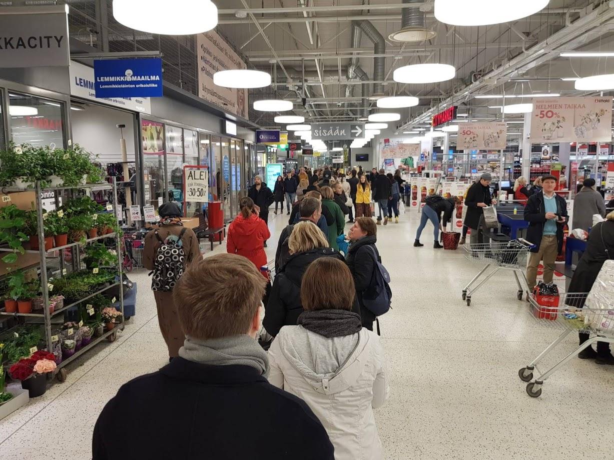 Människor som köar inomhus i en storhandel.