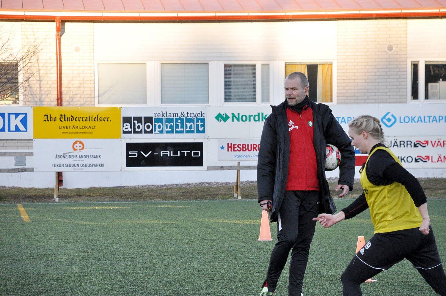 Fotbollsspelare och tränare vid en konstgräsplan