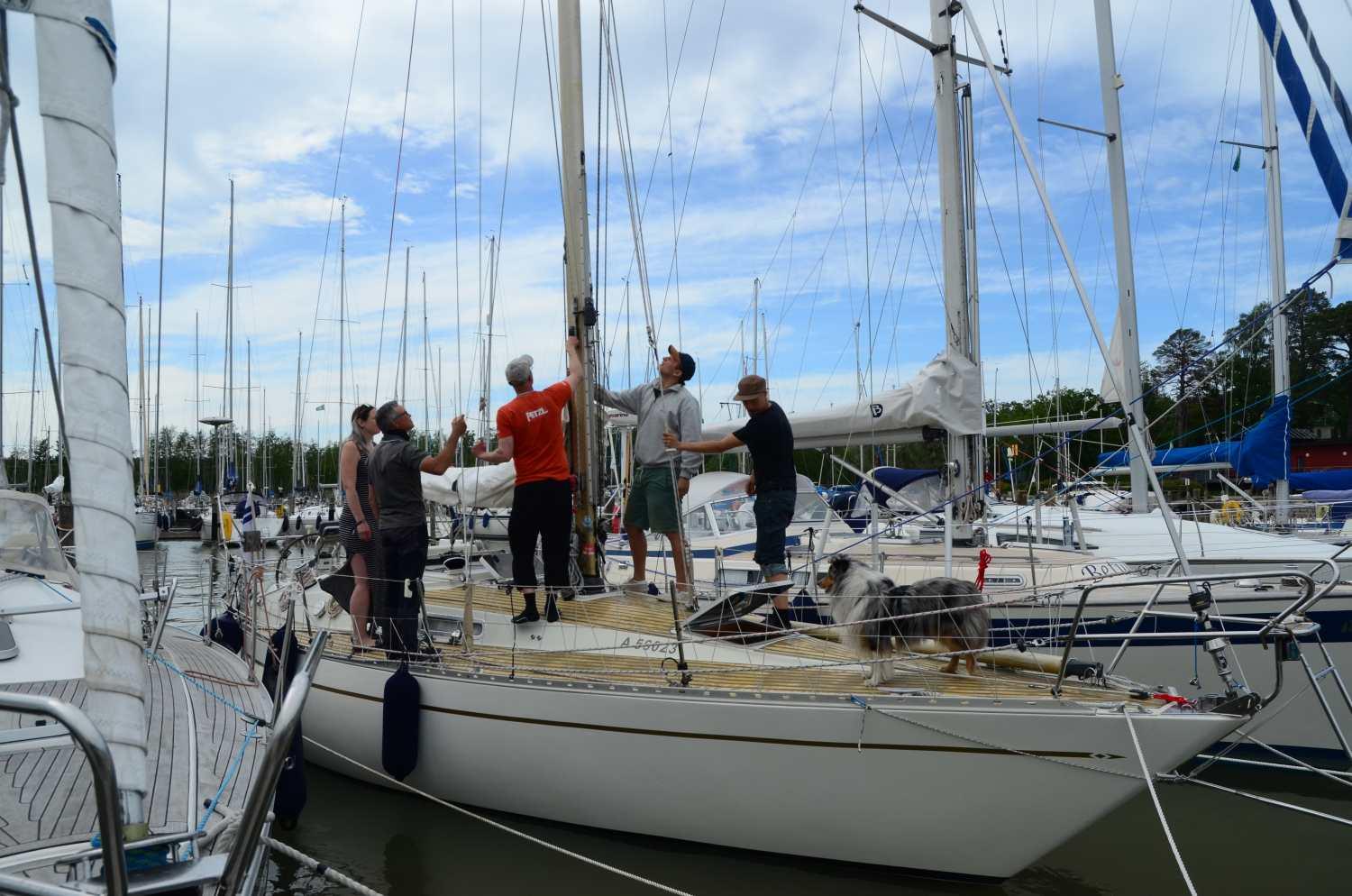 Männsikor står och tittar på en mast ombord på en segelbåt.