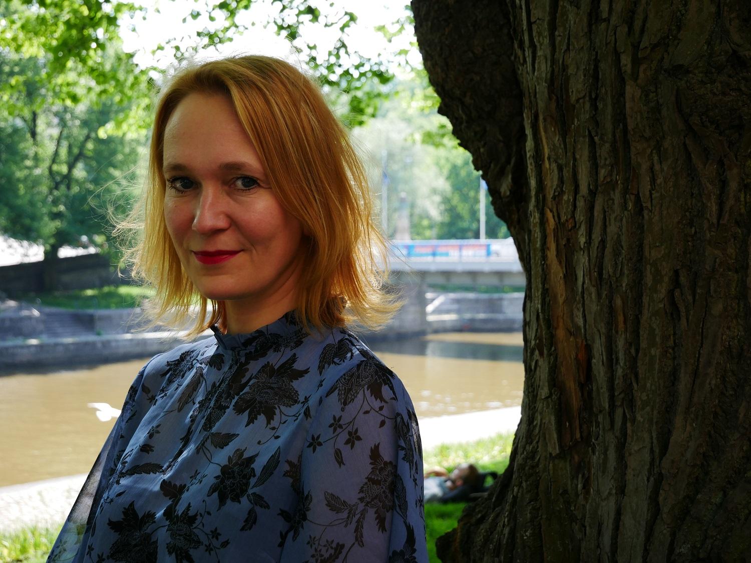 Åsa Slotte, filosofi som disputerar inom ämnet anorexi. Här sitter hon vid Aura Å i Åbo.