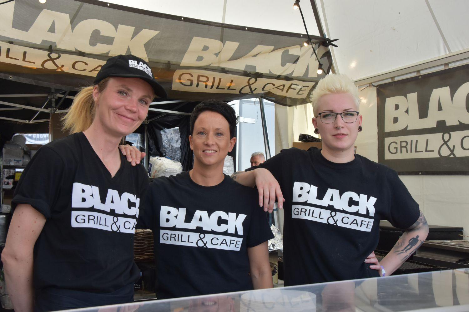 tre kvinnor i "Black bar and café"-t-skjortor.