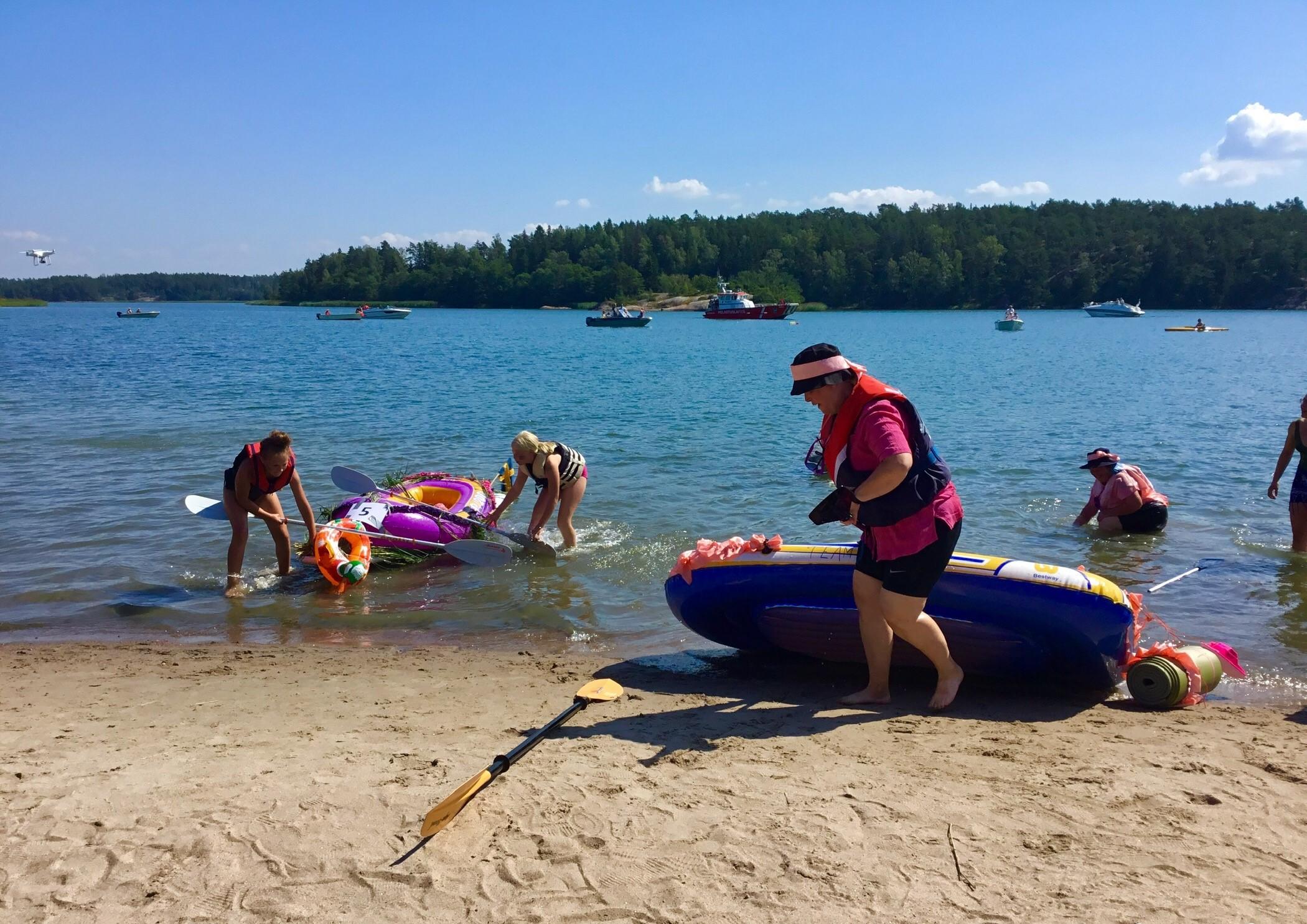 Människor på en strand med flottar.