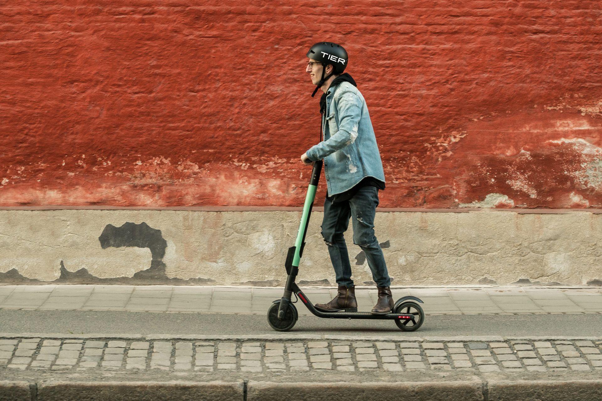 En person åker på en turkos elsparkcykel.
