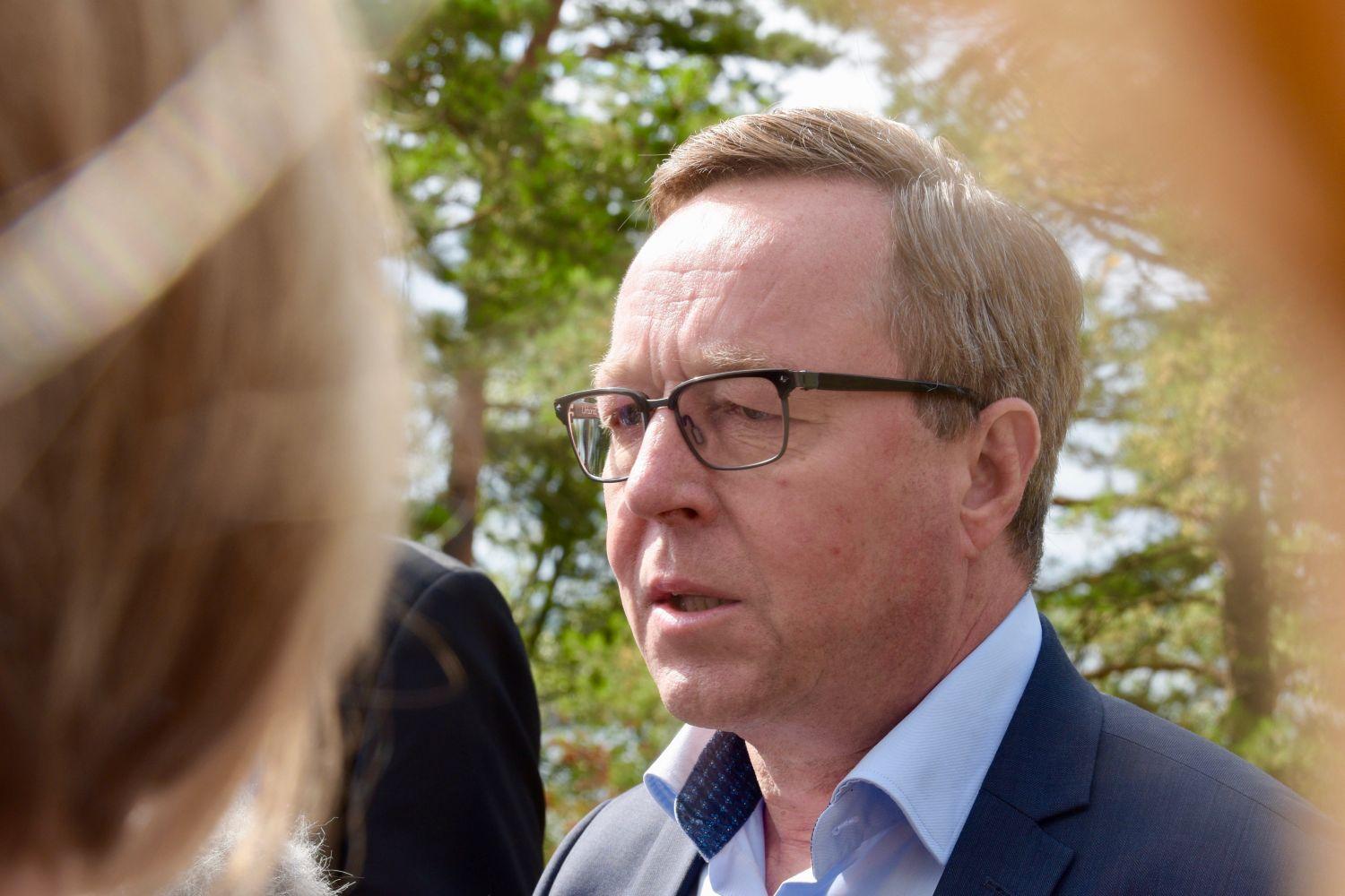 Mika Lintilä, iklädd kostym, ser bekymrad ut.