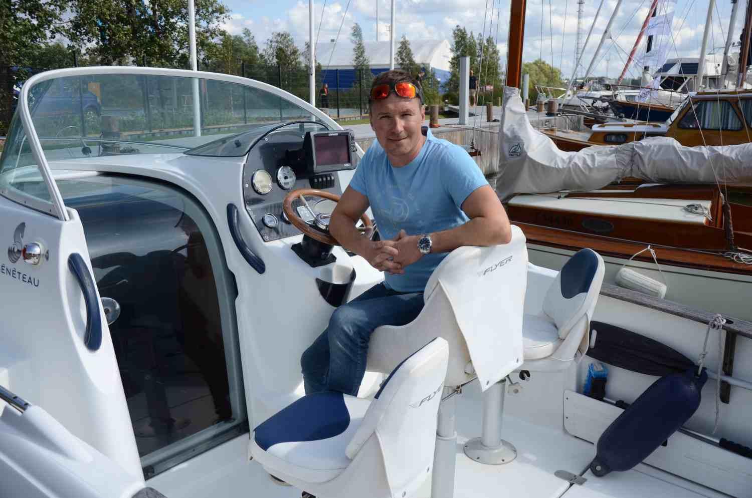 Man i t-skjorta ombord på en motorbåt.
