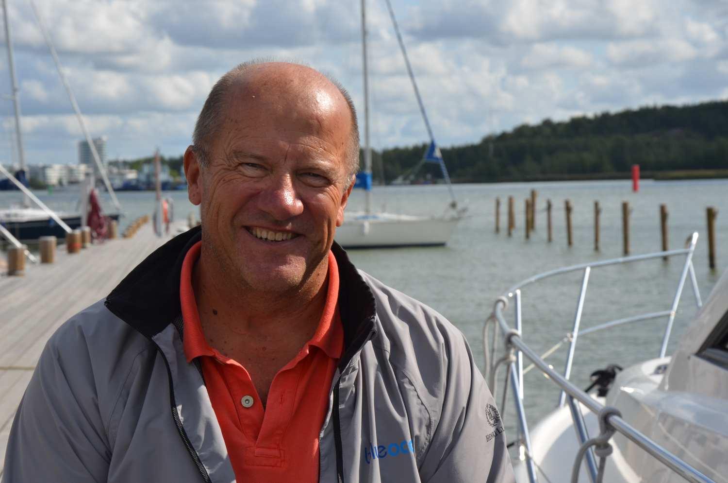 Solbränd medelålders man i en båthamn.