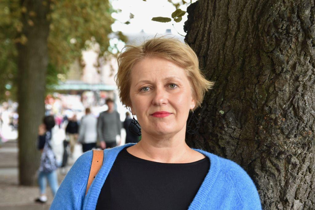 Kvinna står utomhus och ser in i kameran