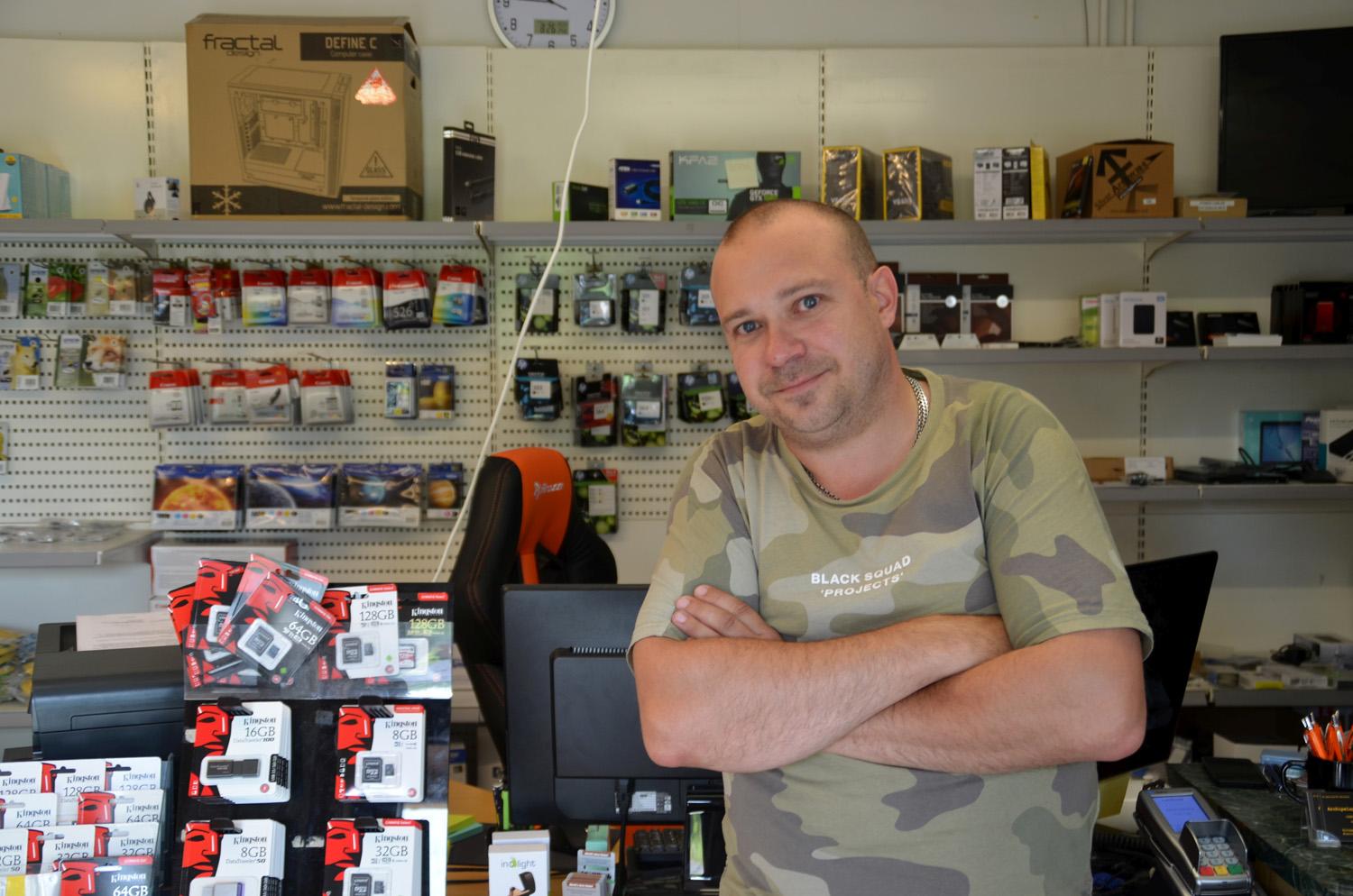 Man står framför butikshyllor med datorvaror