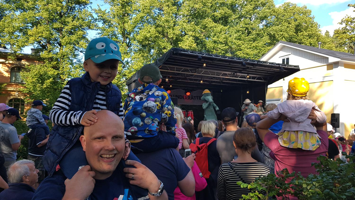Pojke sitter pappas axlar