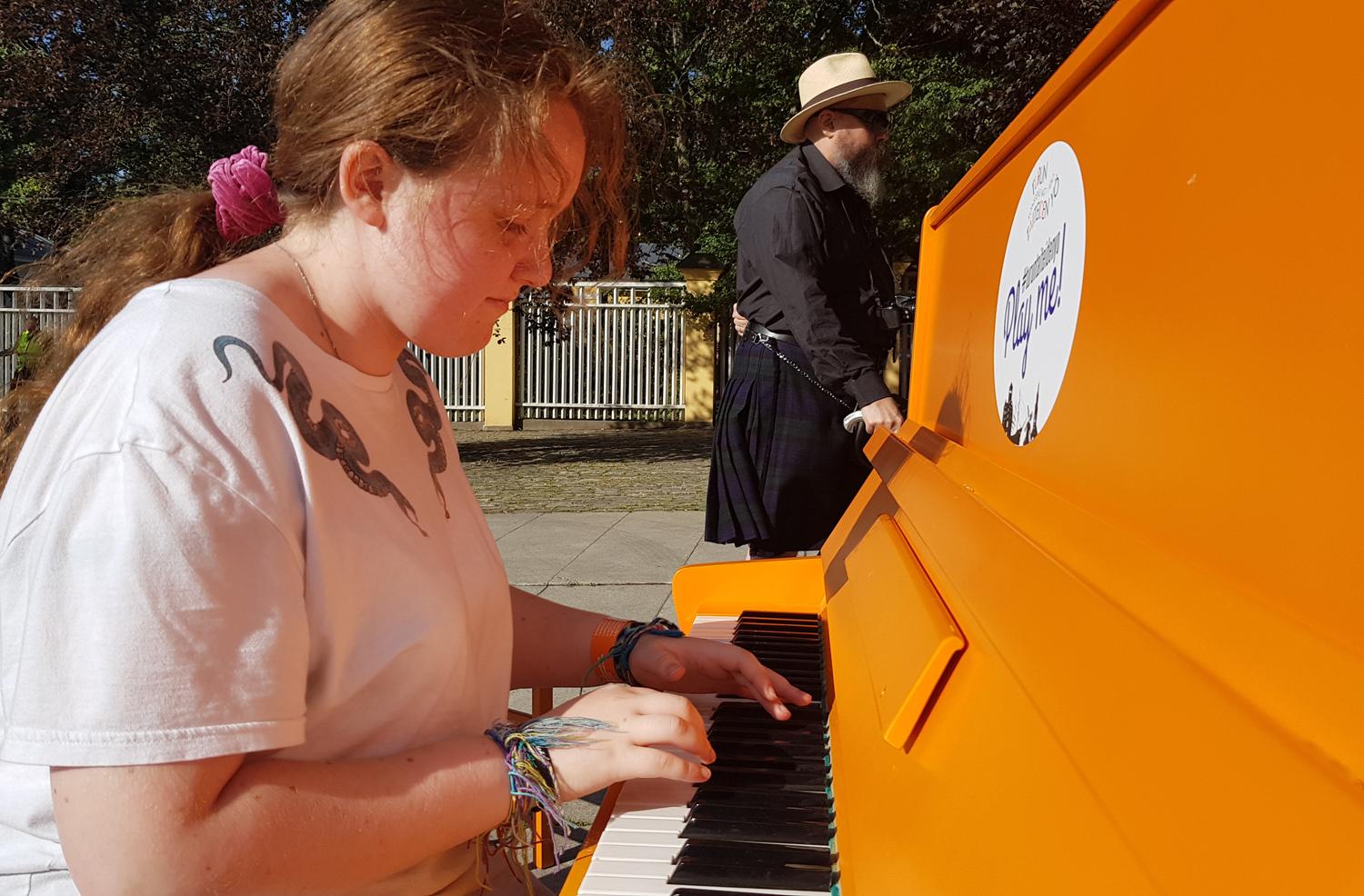 Flicka spelar piano utomhus