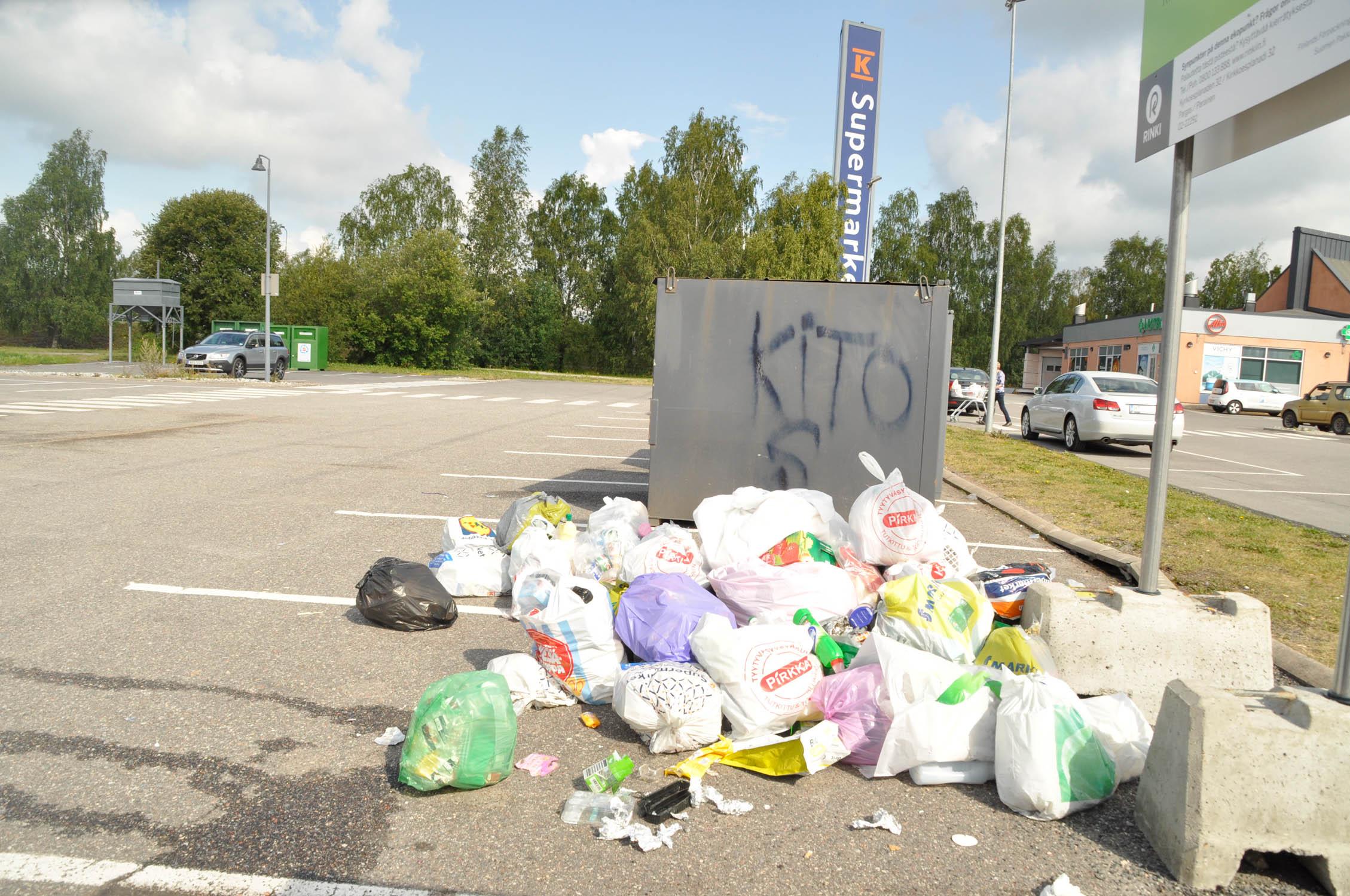 plastskräp vid sidan av sopkärl