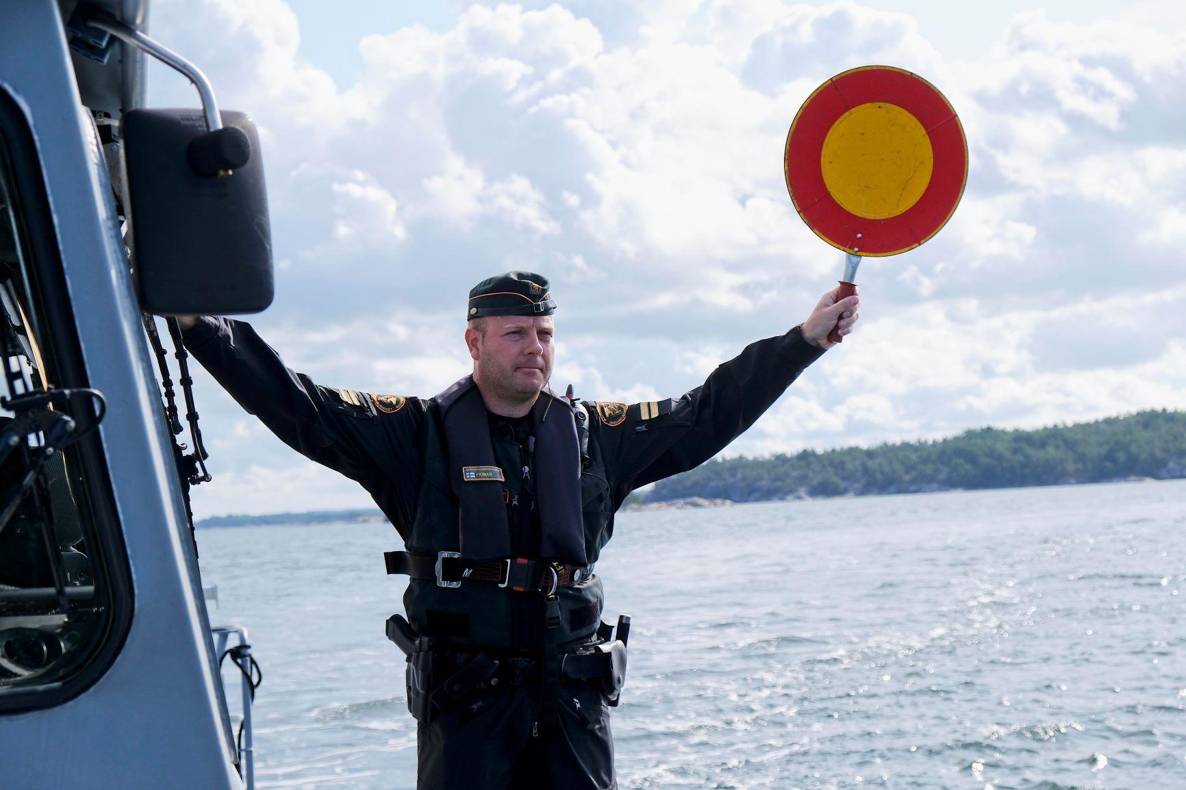 Sjöbevakare håller upp en stoppskylt
