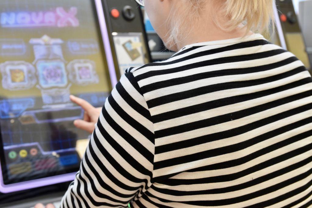 En person står och spelar på en spelautomat