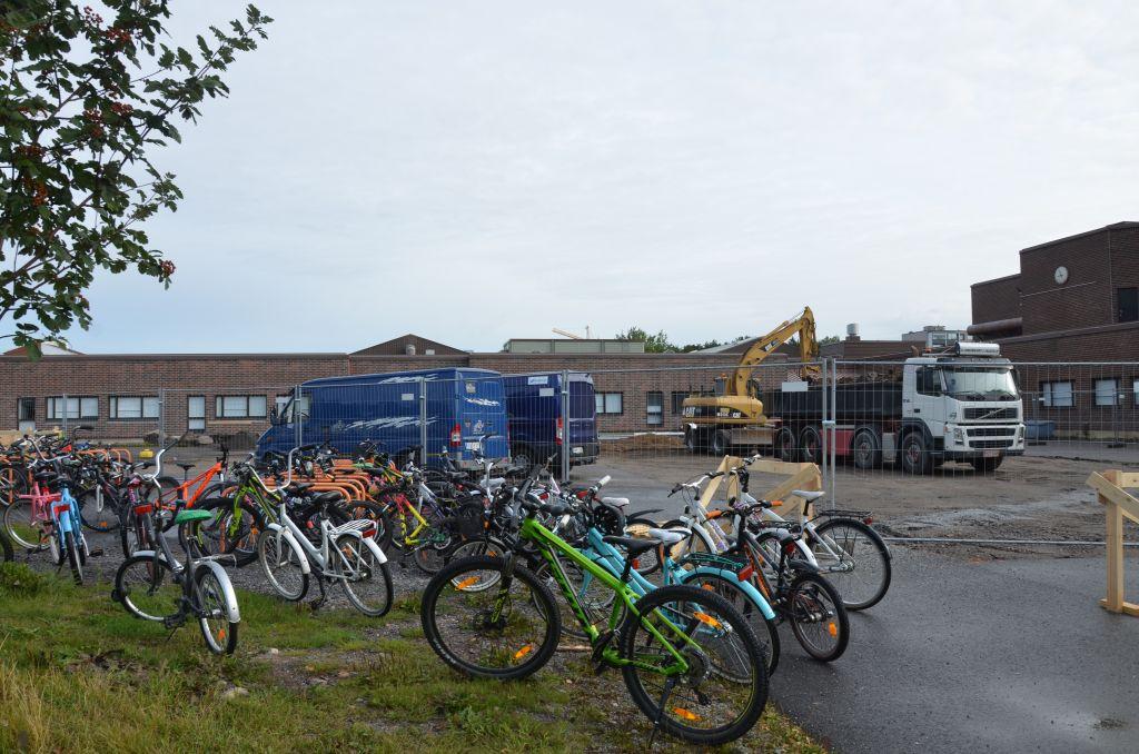 Cyklar står parkerade framför ett staket som omringar en byggarbetsplats