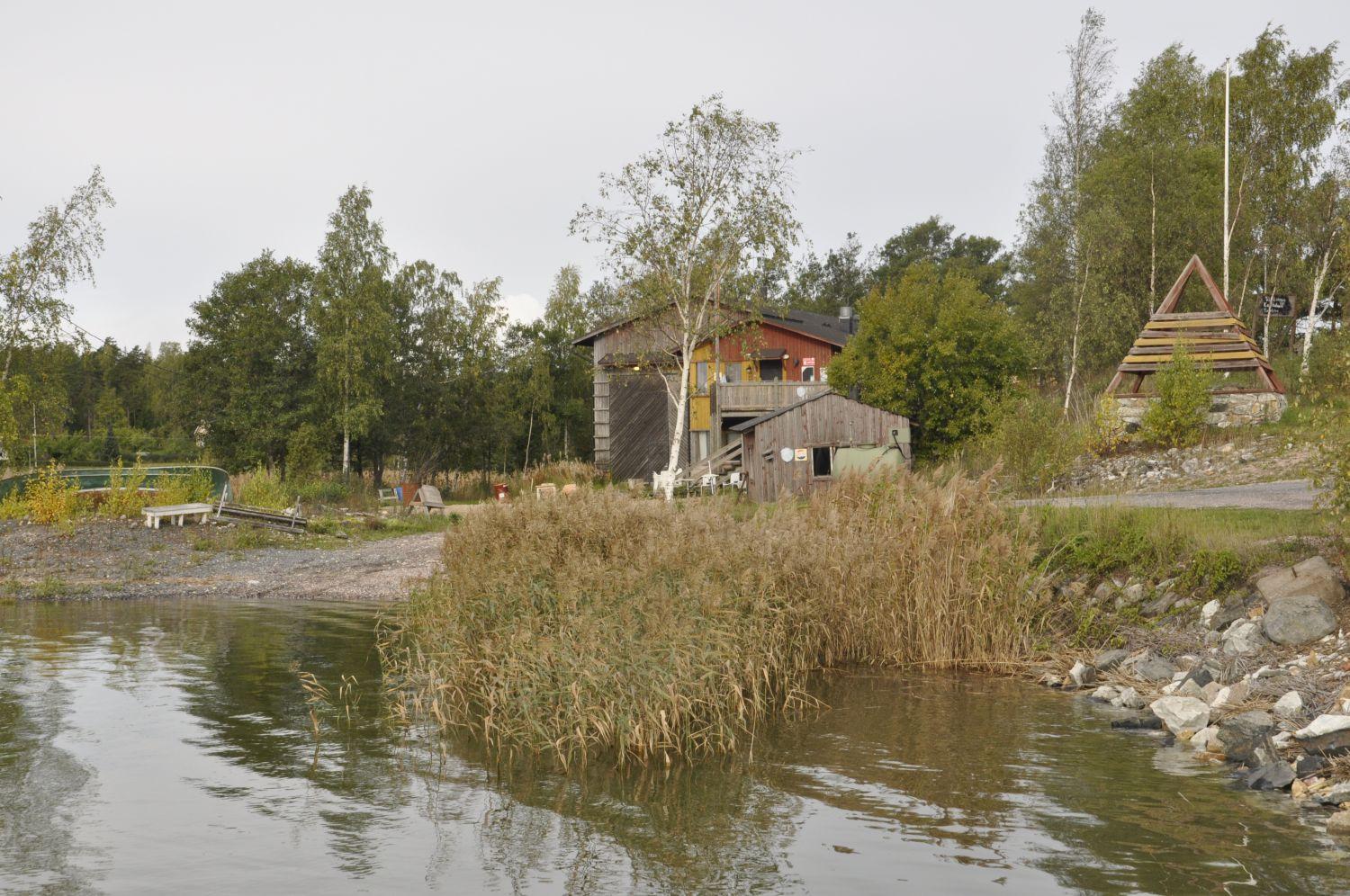 Från havet syns en liten båtupptagningsplats och en byggnad.