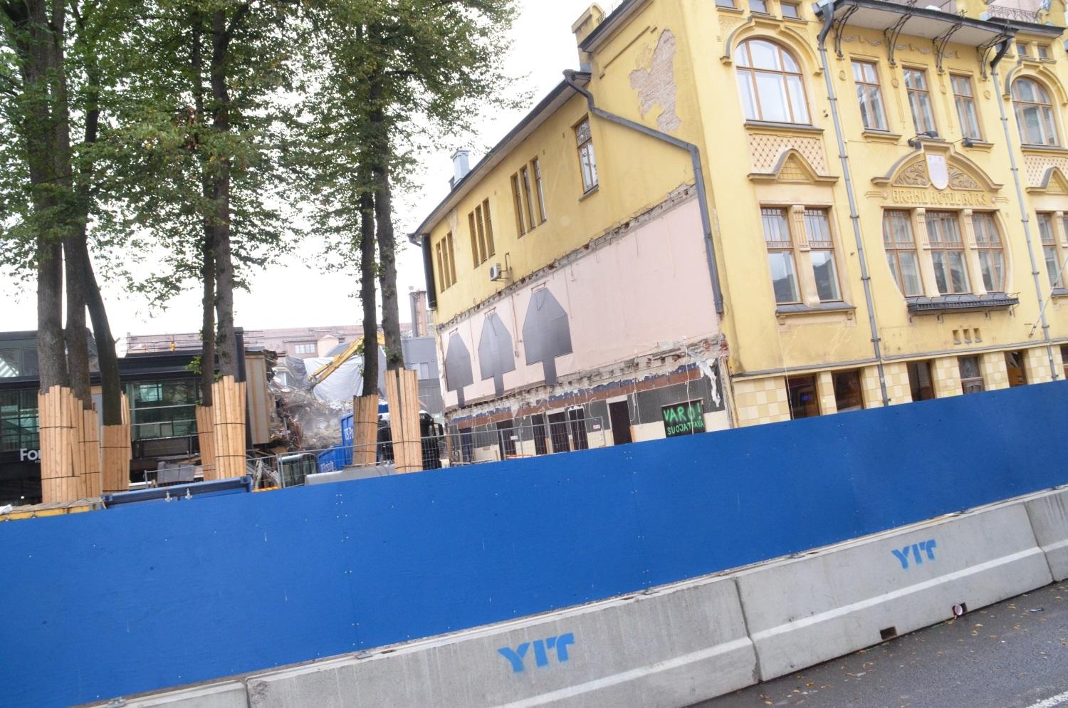 Det gula Hamburger Börs-huset i Åbo centrum, med en grävmaskin i bakgrunden.