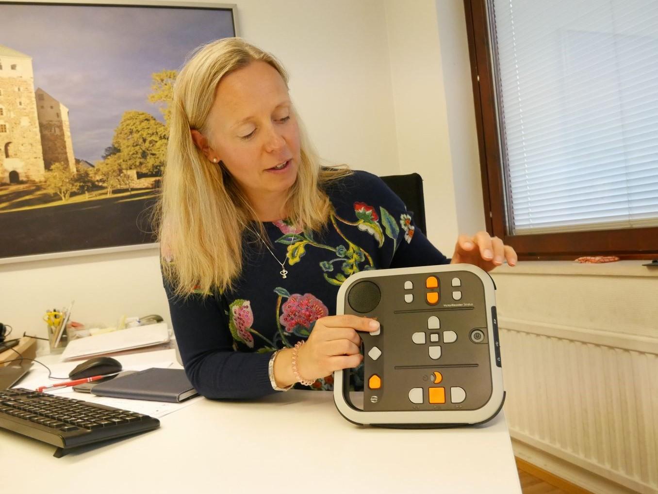 En person håller i en fyrkantig apparat