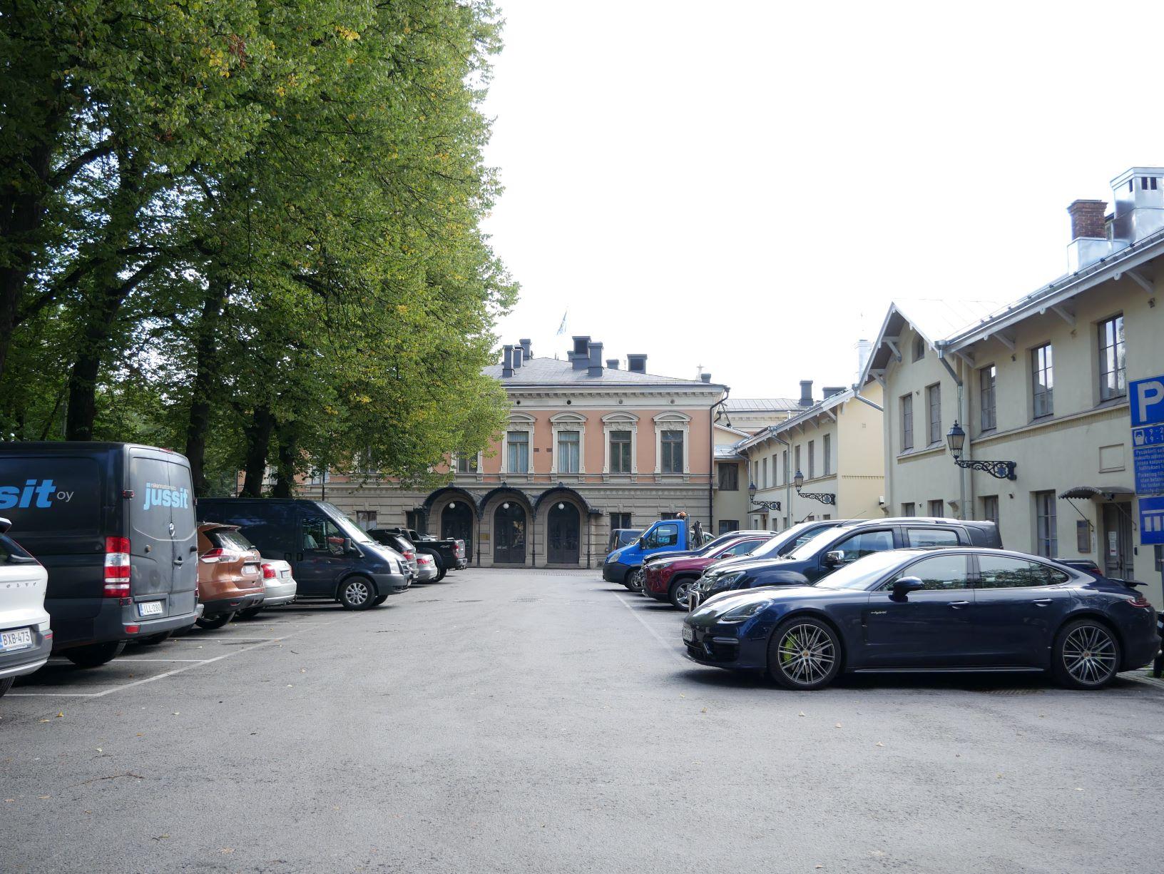 En parkeringsplats mewd stadshuset i bakgrunden
