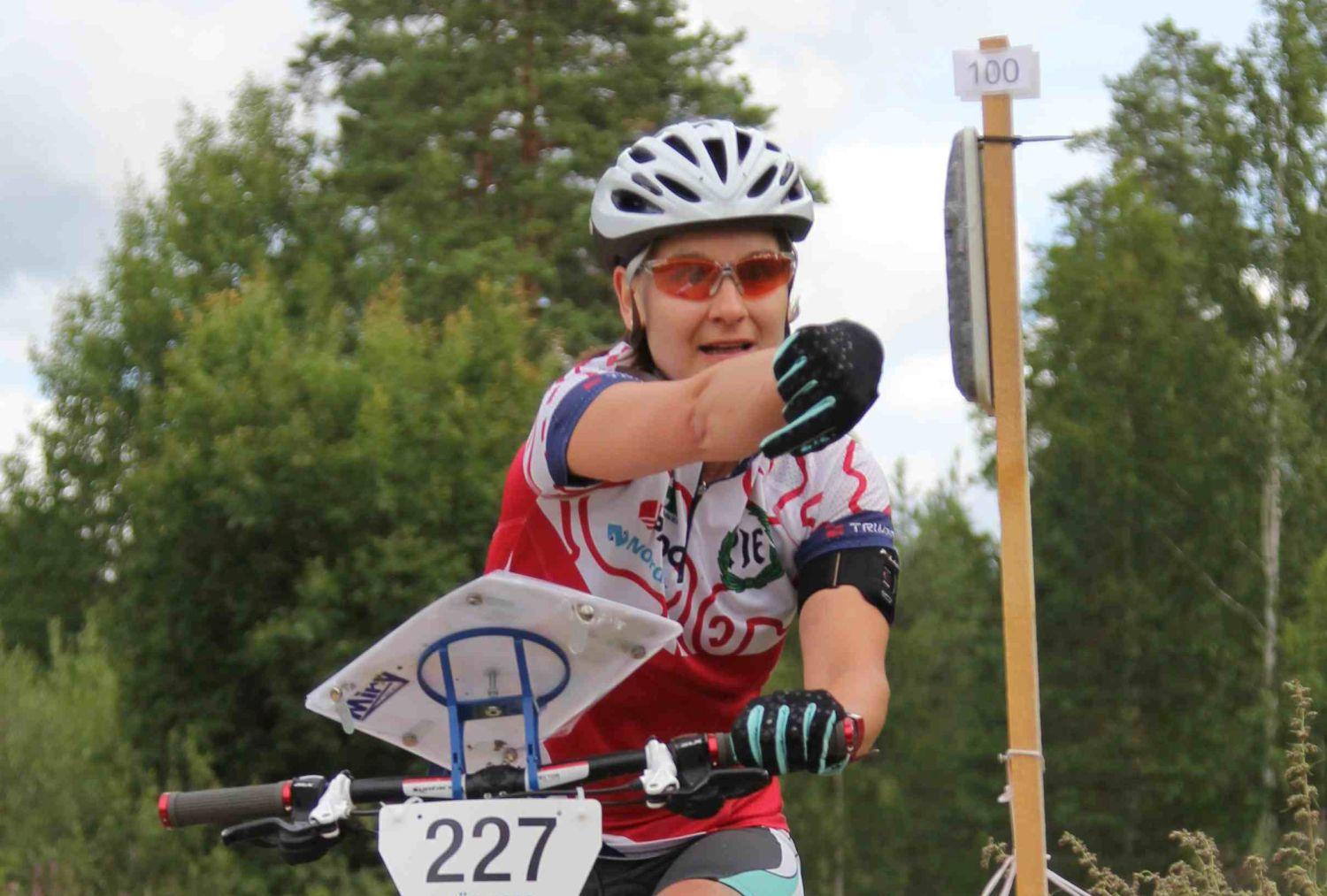 Sportigt klädd kvinna cyklar i terräng