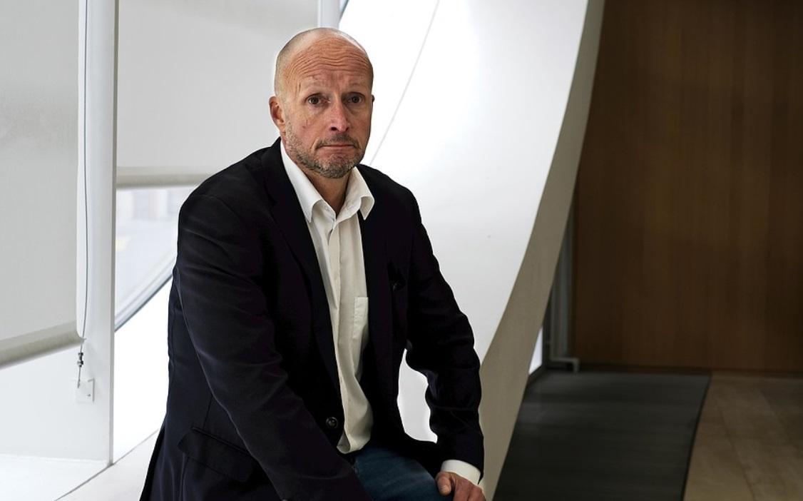 En man sitter vid ett ovalt fönster