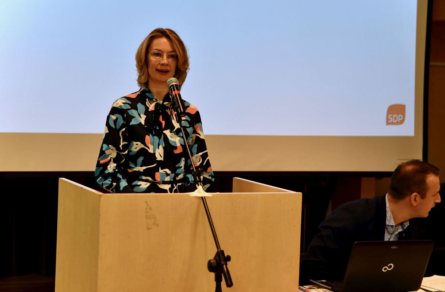 Kvinna som står i en talarstol och talar