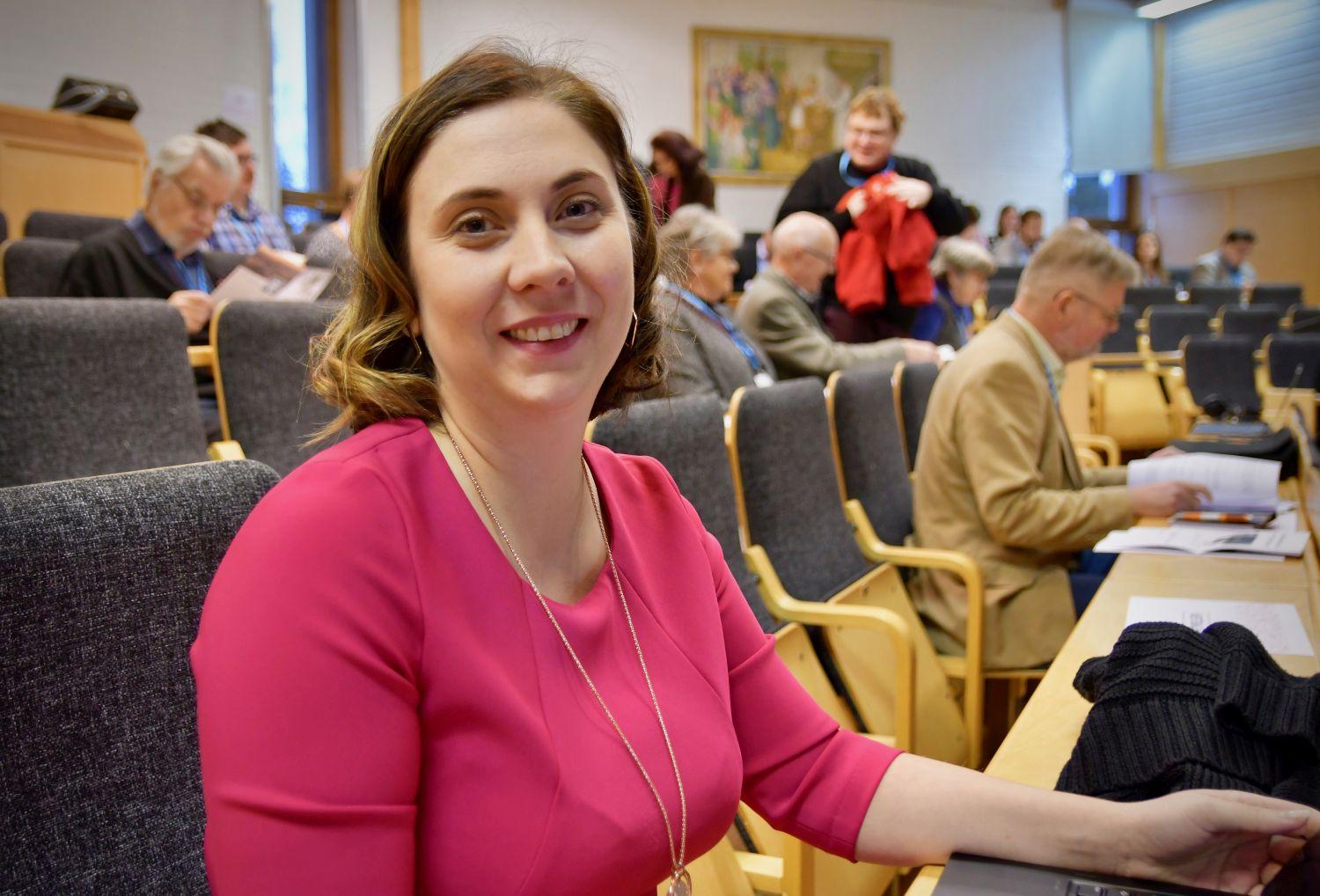 Leende kvinna i ett auditorium.