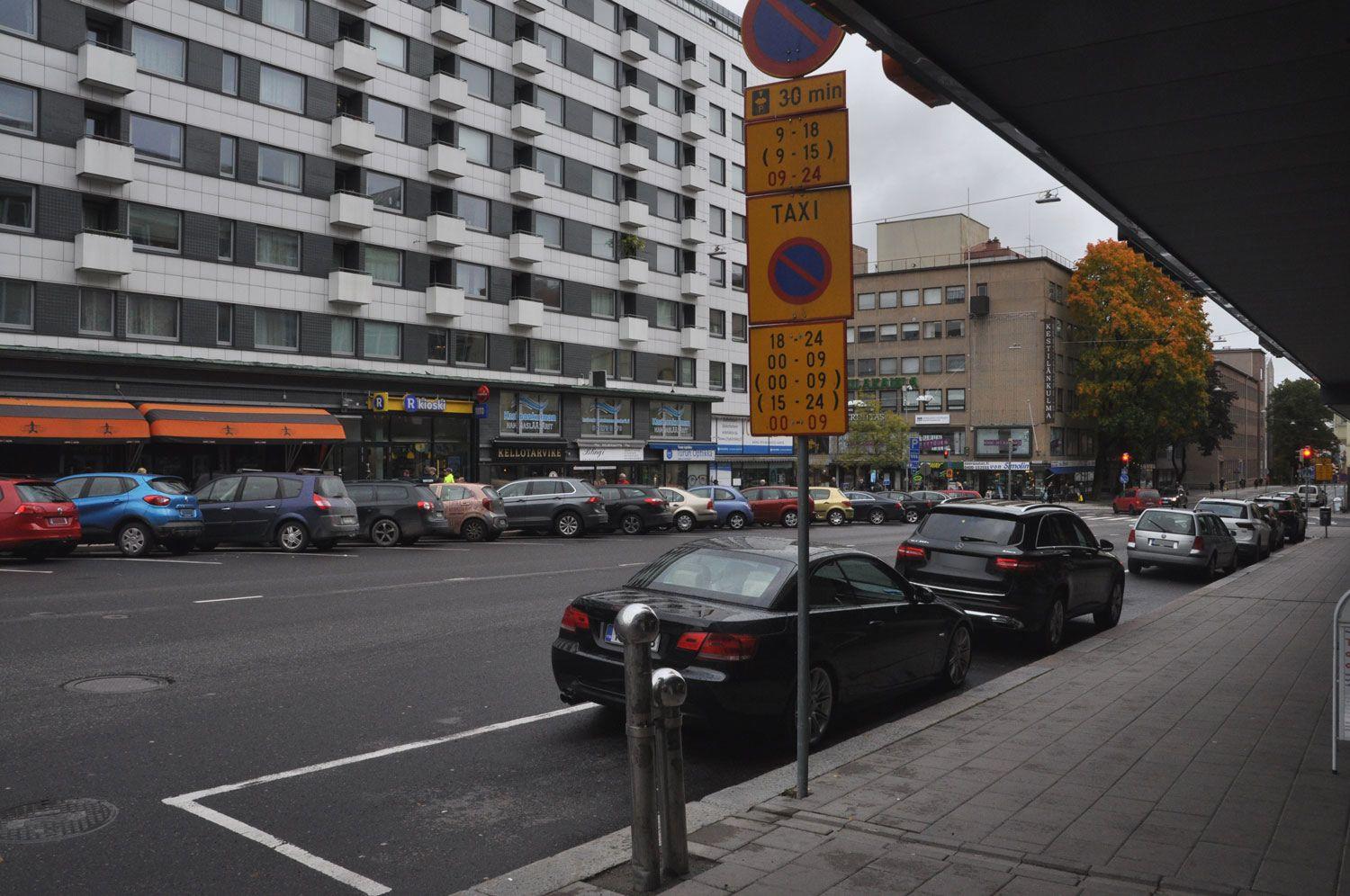 Parkerade bilar och ett trafikmärke.