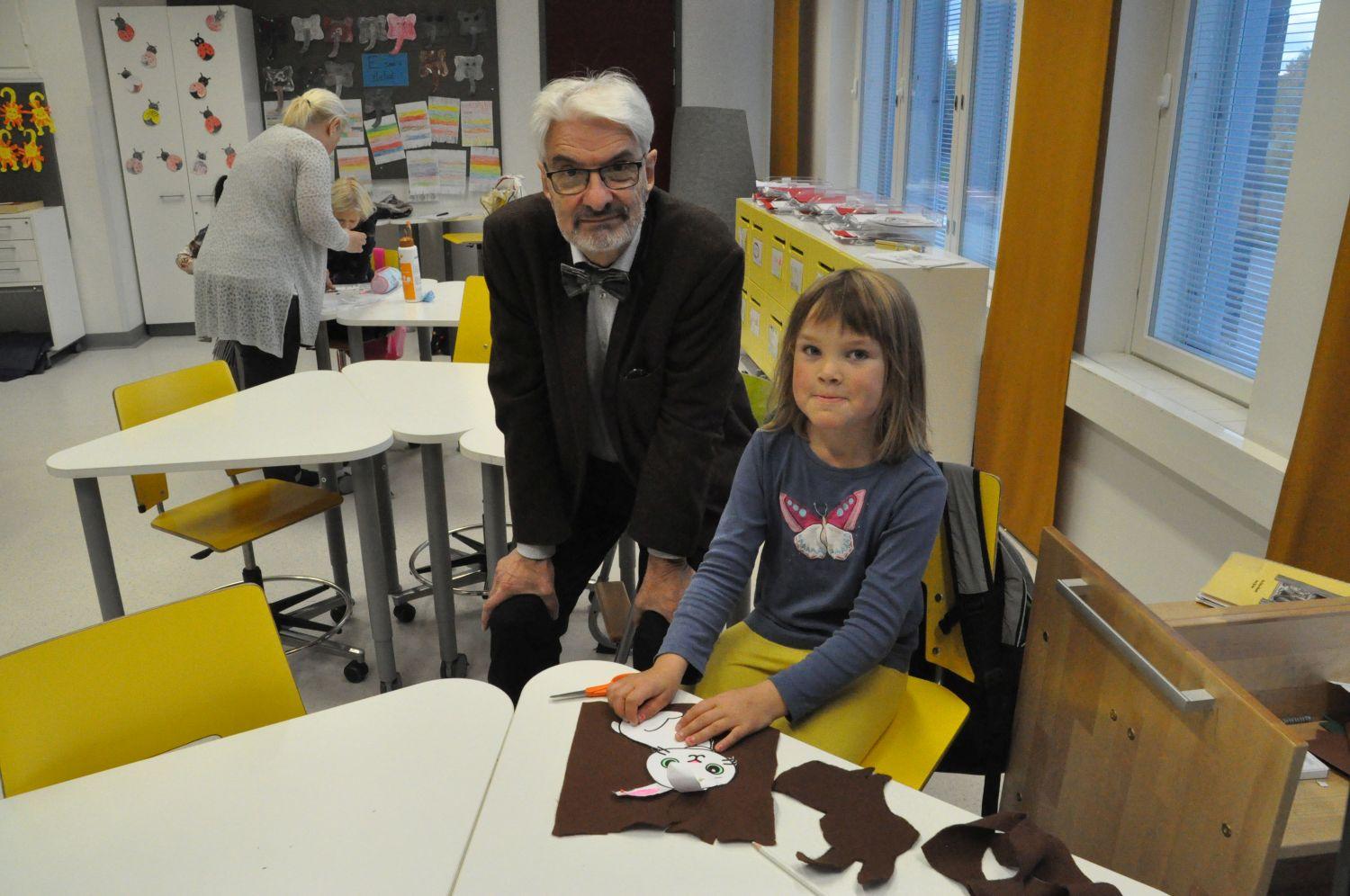 En äldre man och en liten flicka i en skolklass.