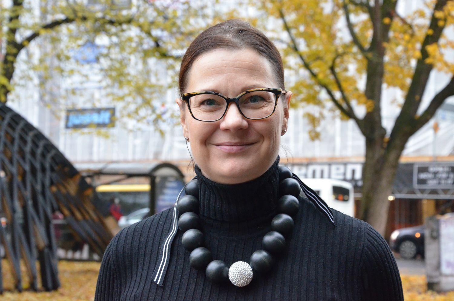 Leende kvinna .ed svart pärlhalsband.