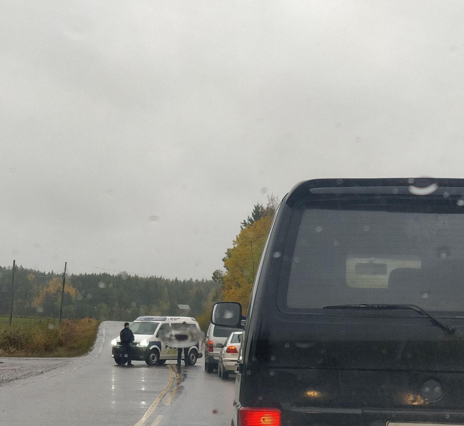 Polisbil och kö av bilar.