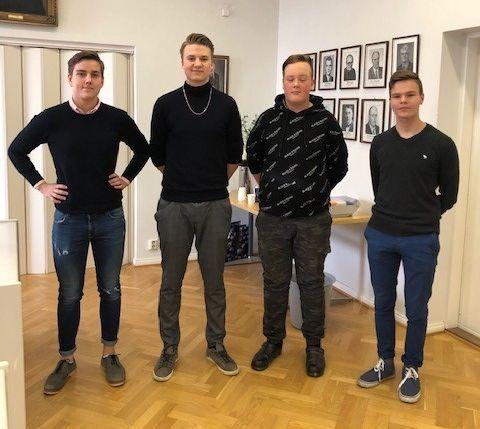 Fyra unga män står på rad