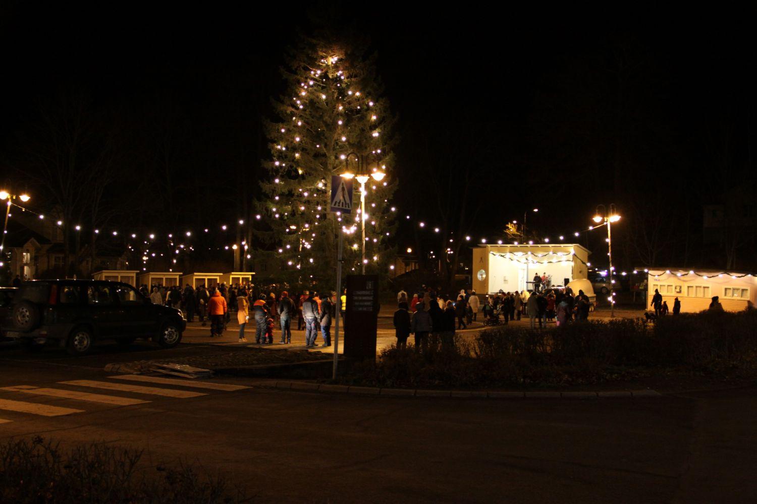 tänd julgran och folkskaror på ett torg