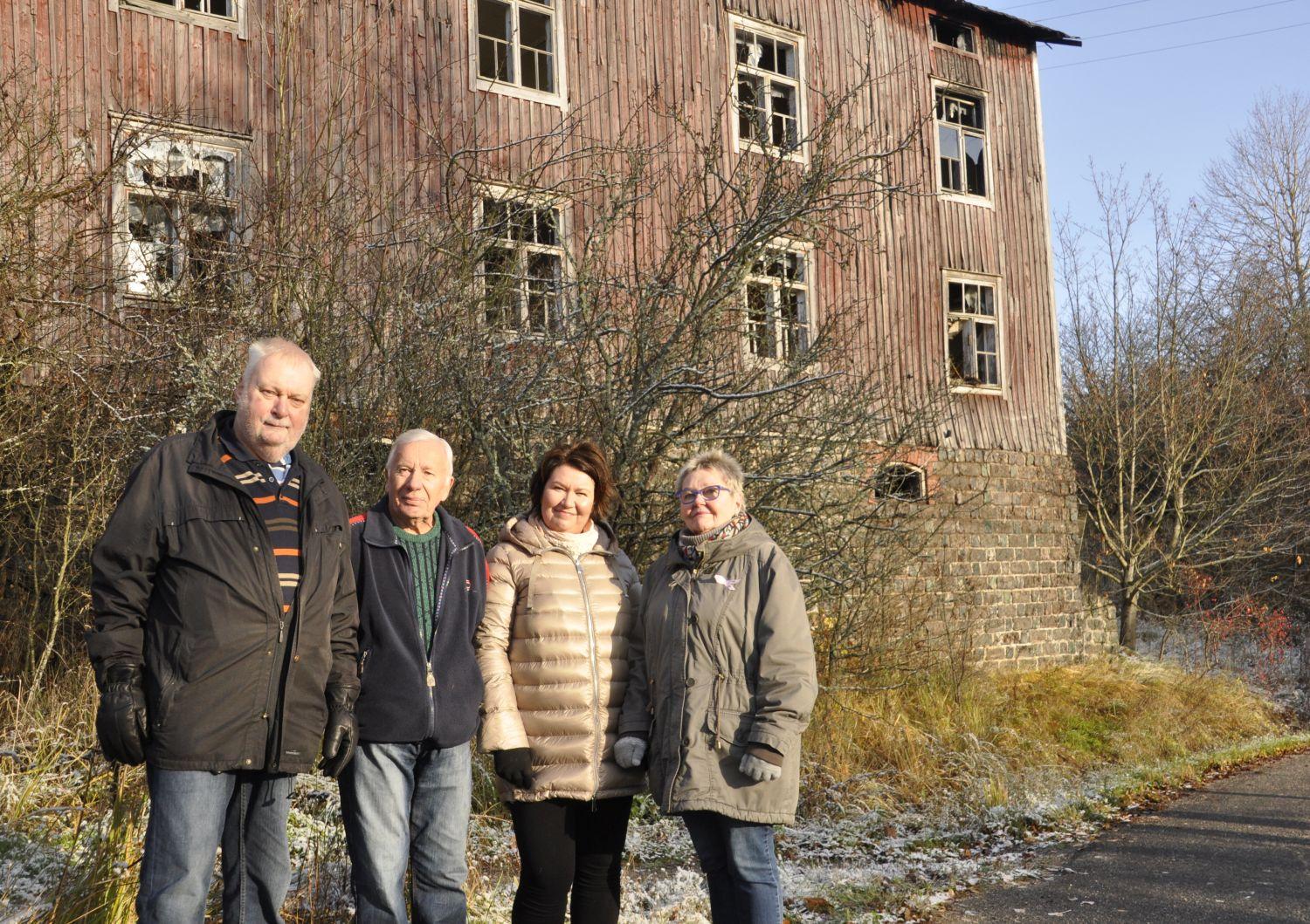 Fyra personer framför att förfallet hus