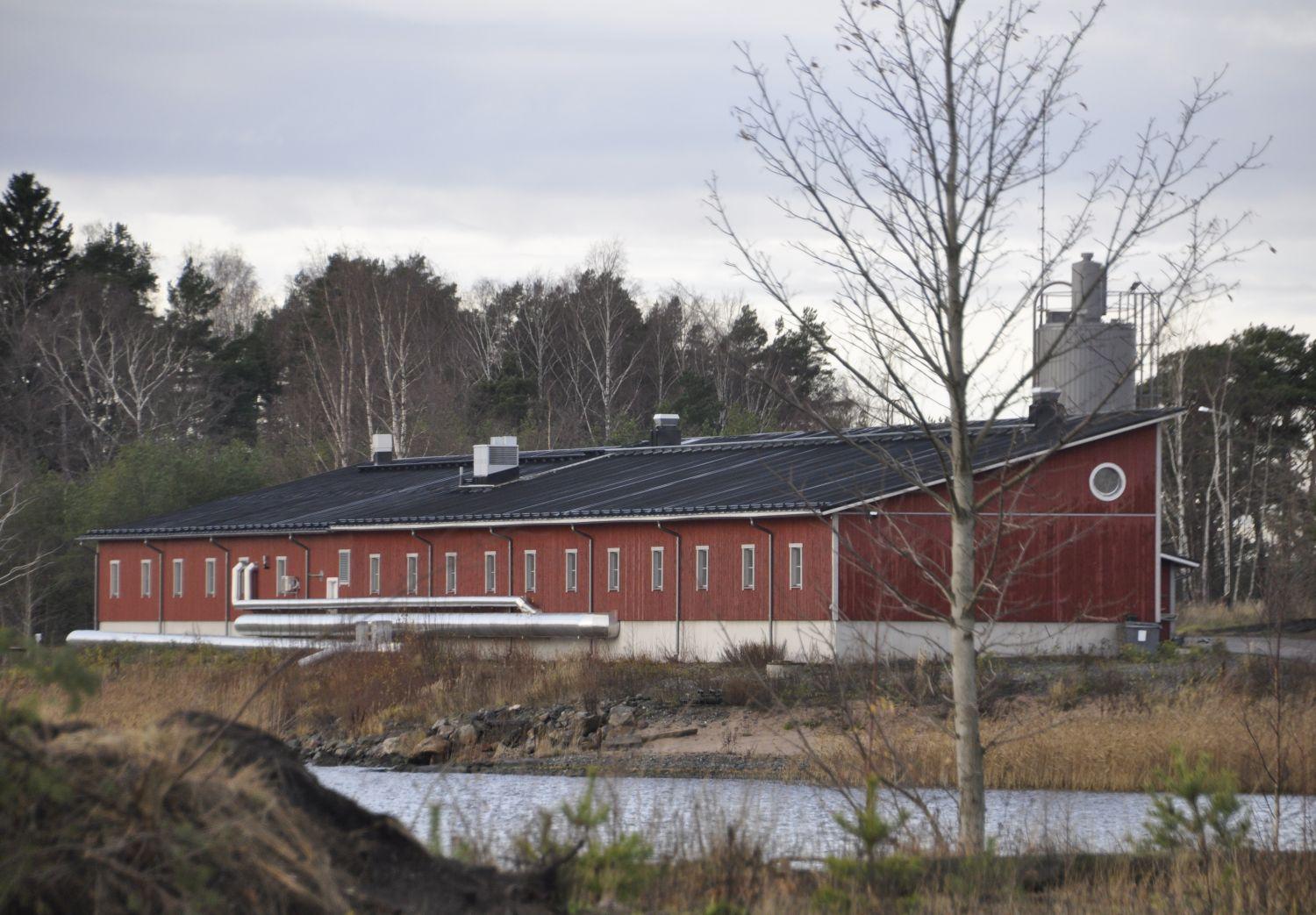 Ett avloppsreningsverk syns på andra sidan viken.
