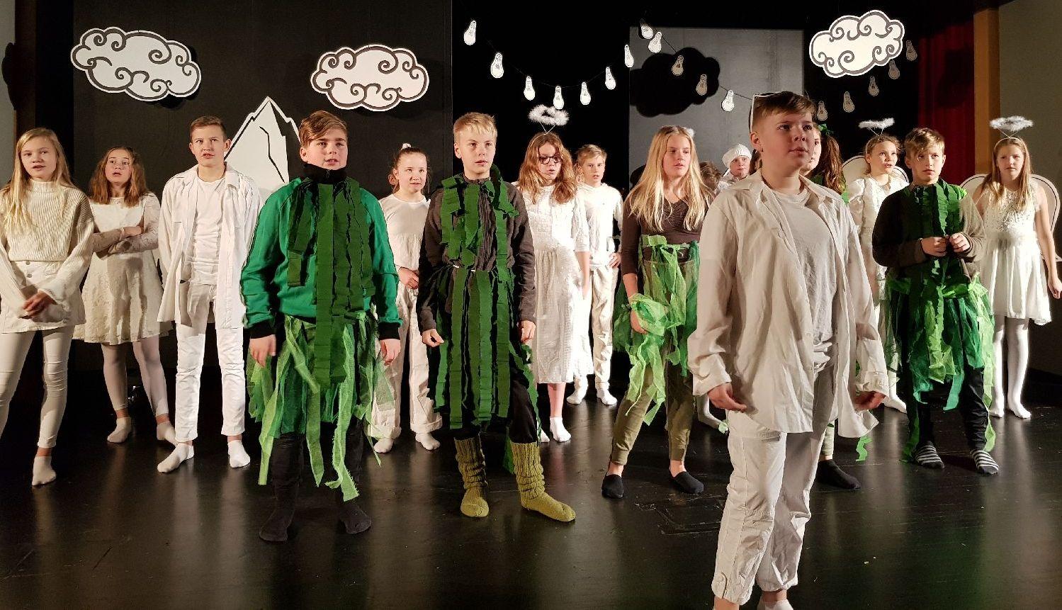 Teatergäng på scenen i vita och gröna kläder