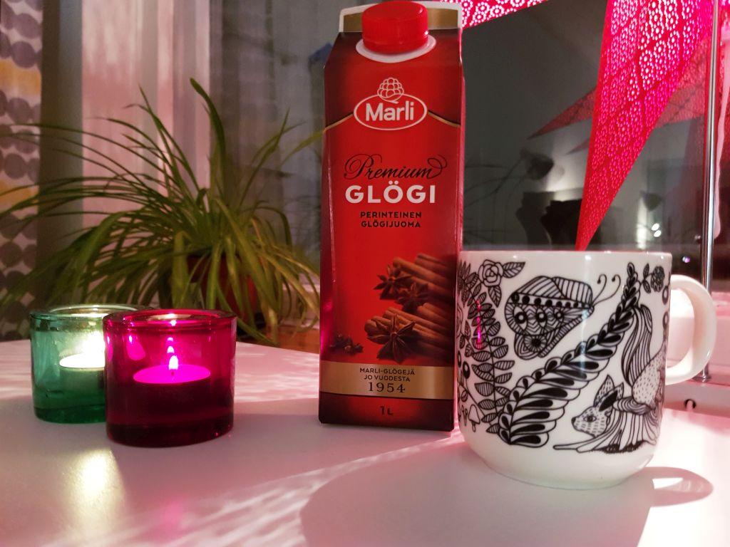 en kopp med glögg och ett glöggpaket, båda på ett vitt bord