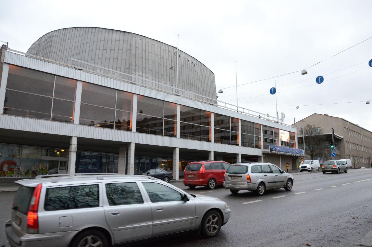 Ett stort hus med trafik i förgrunden.