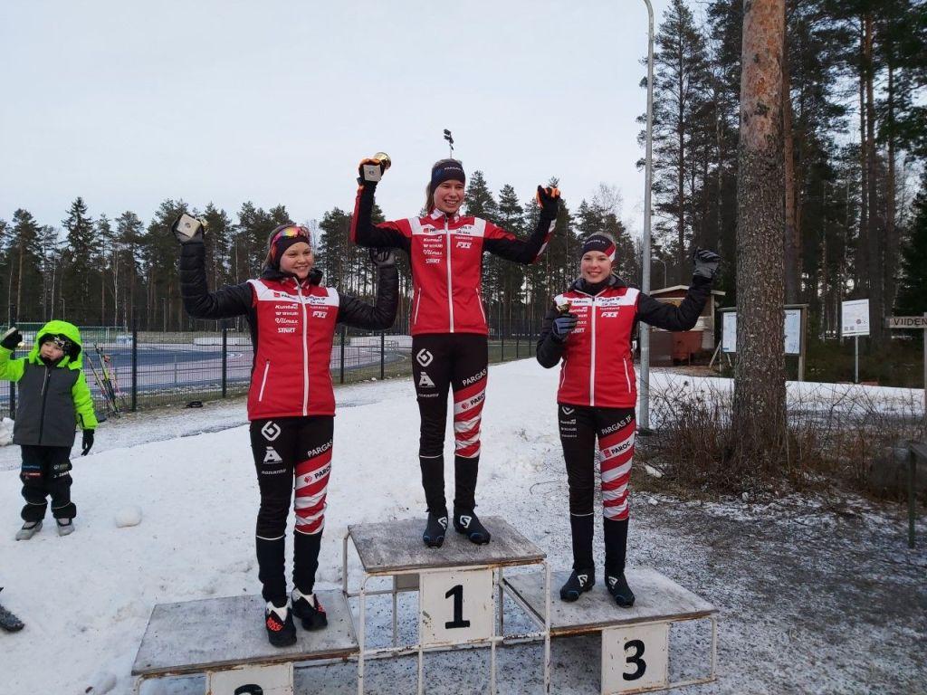 Tre skidåkare med medaljer