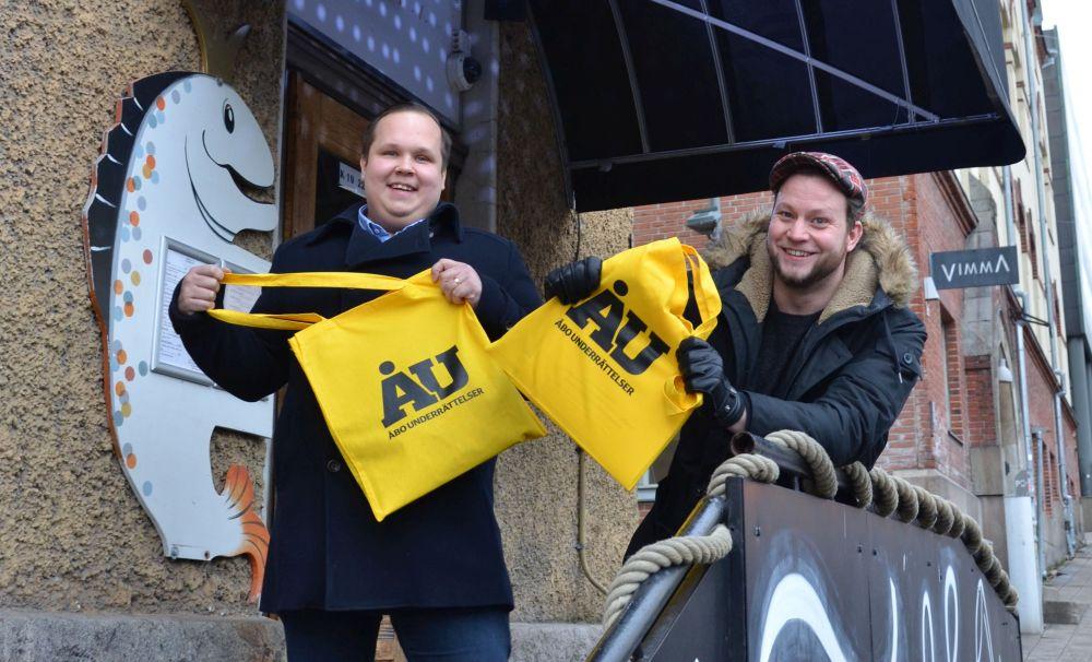 Två glada män i stadsmiljö