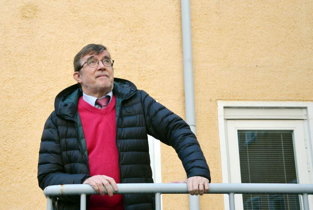 Man lutar mot räcke vid hussvägg