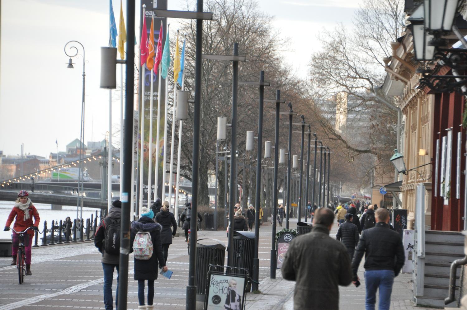 Folk går vid Aura å