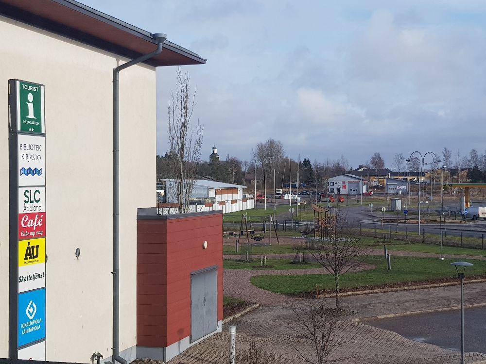 Fotot taget snett uppifrån. En husvägg syns, en innergård, och en park.