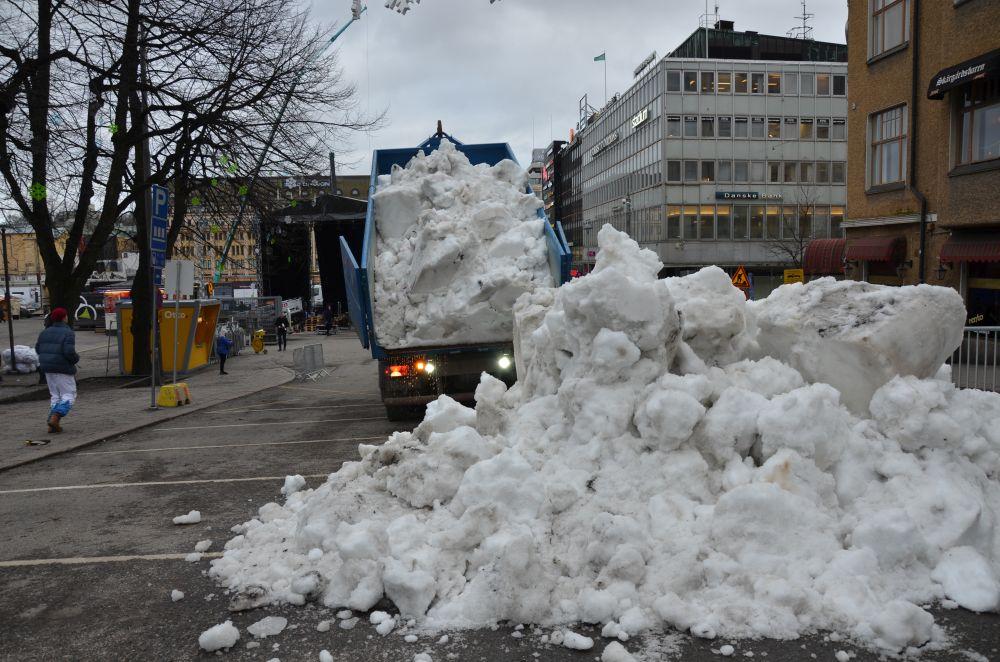 Lastbil kippar snö.