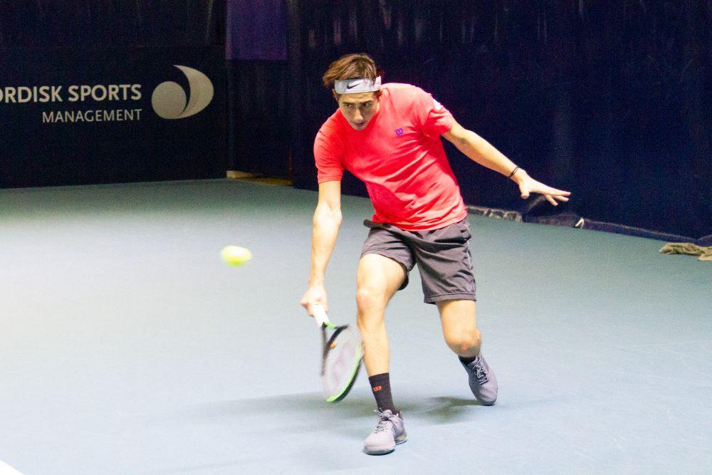 Yngling spelar tennis