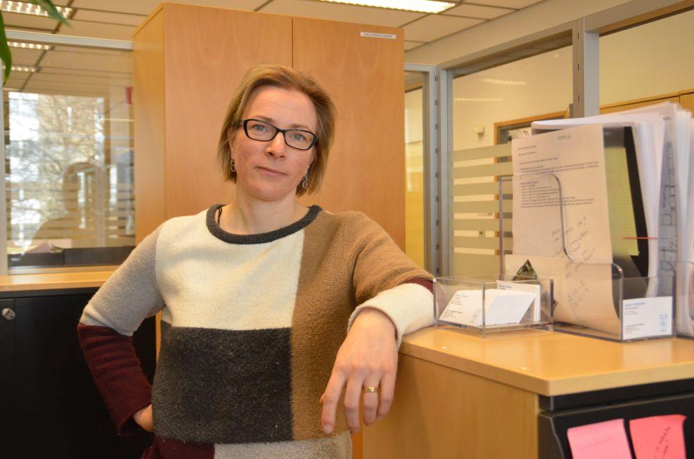 Kvinna lutar sig mot ett skåp.